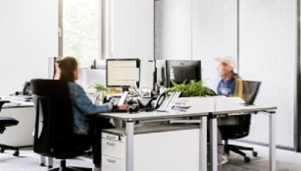 Mitarbeitende an Computern in modernem Büro