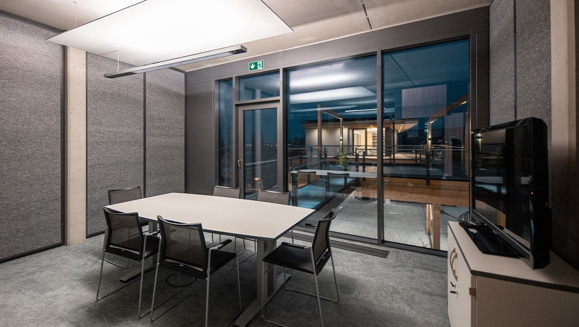 SPRINTIS Konferenzraum mit Konferenztisch, Glasfront und Blick auf die Dachterrasse